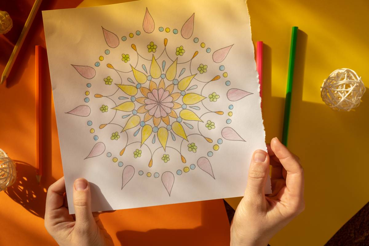 Female painting mandalas antistress page to combat stress. Relaxing hobby mental wellbeing and art therapy. Woman paints sketch, meditative process of coloring pages. Self expression by art