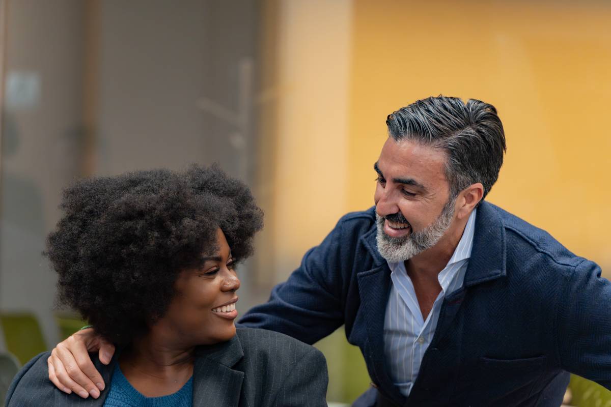 Laughing colleagues in a friendly office interaction.